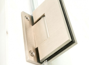 Close up of hing on shower door with notched glass